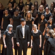 Students standing on stage singing